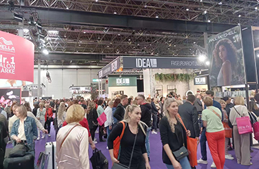 Visitors exploring booths at a busy exhibition, including IDEAL and DEAN