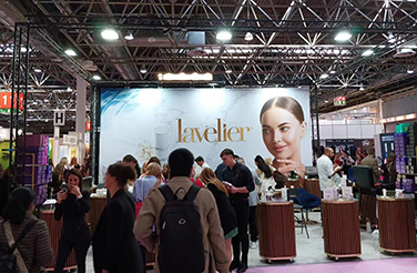 Lavelier Booth At An Exhibition, With Visitors Interacting And Exploring Skincare Products